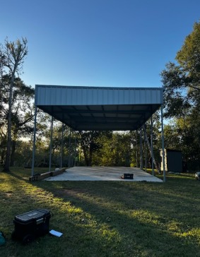 Completed custom metal pavilion at dusk with concrete pad